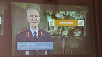 Blick auf die Leinwand auf der sich ein Soldat in Uniform befindet