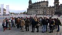 Eine Personengruppe steht auf dem Theaterplatz und bespricht den weiteren Ablauf.