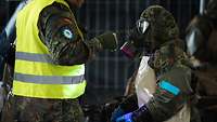 A soldier shines a black light on a female soldier