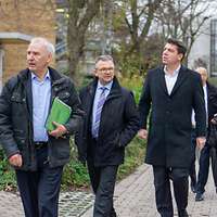 Vier Männer und zwei Frauen laufen über den Bildungscampus.