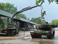 Ein Panzer wird von einem Soldaten dekontaminiert.