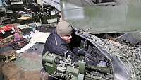 Ein Soldat führt Reparaturen an einem gepanzerten Fahrzeug durch.