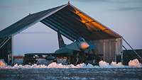 Ein Eurofighter steht unter einem Planeport. Um den Planeport befindet sich Schnee.