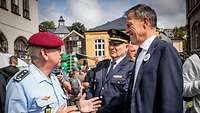 Ein Soldat unterhält sich mit zwei Männern 