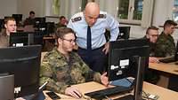Generalleutnant Katz steht hinter einem Soldaten, der an einem Computer sitzt. 