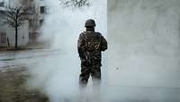 a soldier is standing on the corner of a house in the fog