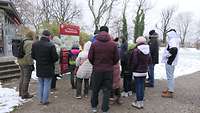 Gruppe von Angehörigen vor einer Informationstafel im Archäologischen Park
