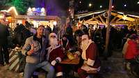 Ein Angehöriger auf dem Schoß von einem Nikolaus auf dem Weihnachtsmarkt
