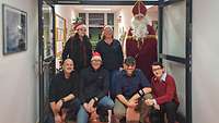 Gruppenfoto mehrerer Erwachsener mit Nikolaus