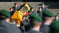 Soldaten tragen einen Sarg mit der Bundesdienstflagge eine Treppe hinunter