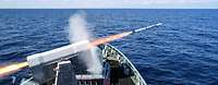 Ein Schiff schießt einen Flugkörper ab.