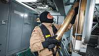 Das Waffensystem wird von einem Soldaten mit Munition befüllt.