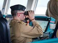 Ein Mann in Uniform schaut durch ein Fernglas.
