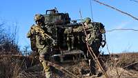 Soldaten steigen aus einem Schützenpanzer durch die Heckklappe aus.