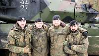 Gruppenbild mehrerer Soldaten vor einem Panzer.
