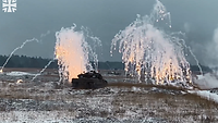 Zwei Panzer stehen im Gelände. Über ihnen geht ein Nebelregen mit Funkenflug nieder, zur Tarnung. 