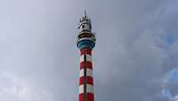 Man sieht einen rot-weiß angestrichenen Turm. Oben befinden sich Antennen.
