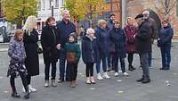 Eine Menschgruppe steht bei einer Stadtführung auf dem Schlachtermarkt in Schwerin.