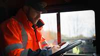 Ein Lkw-Fahrer verfolgt in der App die logistischen Planungen im Aufmarschgebiet. 