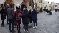Mehrere Menschen stehen bei einer Stadtführung auf dem Schlachtermarkt in Schwerin.