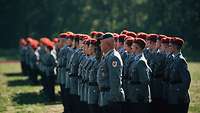 Soldaten stehen in Formation auf einem Platz.