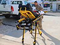Eine rollbare Trage aus dem Krankenwagen wird von einem Soldaten geschoben. 