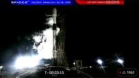 A rocket is standing on the launch pad in the dark.