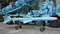 Eine hellblaue Rakete liegt auf einem kleinen Rollwagen.