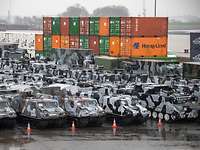 Militärfahrzeuge und Container warten auf die Verladung.