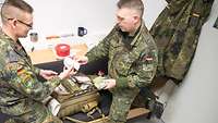 Zwei Soldaten kontrollieren das Material in einem Einsatzersthelfer-Rucksack