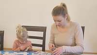 Eine Mutter bastelt mit ihrer Tochter schöne Sachen.
