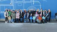 Eine Gruppe Menschen stellt sich zu einem Gruppenbild auf.