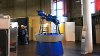 Mehrere Angehörige stehen im Planetarium vor Wandtafeln und Projektoren.
