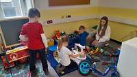 Mehrere Kinder spielen in einem kleinen Raum 