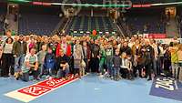 Eine Personengruppe hat sich zu einem Gruppenbild zusammen gestellt. 