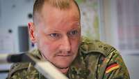 Ein Soldat sitzt vor einer Lagekarte