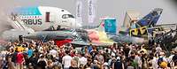 Eine Menschenmenge bewegt sich zwischen mehreren Flugzeugen