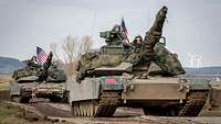 Zwei US-Panzer mit Nationalflaggen hintereinander