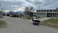Im Hintergrund steht ein Gebäude mit dem Schriftzug ITP Prizren, davor fährt ein Transporter vorbei.