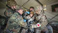 Mehrere Soldaten halten einen Patienten fest