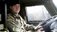 Ein Soldat in Uniform sitzt in einem militärischen Fahrzeug.