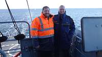 Ein Marinesoldat und ein Militärrabbiner in Uniform posieren für ein Foto auf dem Schiffsdeck.