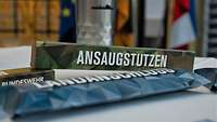 Ein olivgrüne Kartonschachtel mit der Aufschrift ,,Ansaugstutzen''