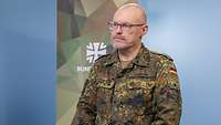Eine Soldatin interviewt einen Soldaten vor einem Bildschirm in einem Studio