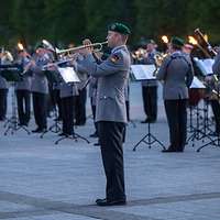 Ein Trompeter der Bundeswehr spielt Musik. Im Hintergrund weitere Soldaten beim Musizieren.
