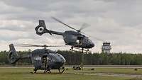 Two H145M land at an airfield.