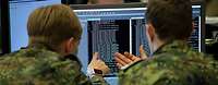 Zwei Soldaten sitzen vor einem Monitor.