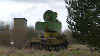 Der Radarpanzer steht auf einer Wiese. Um ihn herum stehen Soldaten. 