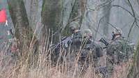 Soldaten beim Kompaniegefechtsschießen in einem Waldstück