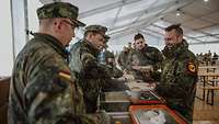 Soldaten in einem großen Zelt geben Mittagessen aus